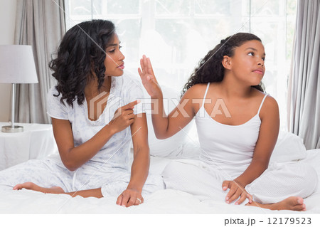 Mother and daughter having an argument on bed 12179523
