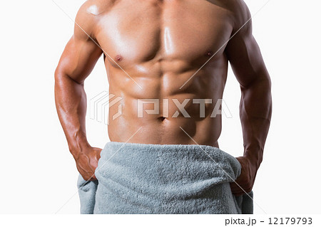 Mid section of a shirtless muscular man wrapped in towel 12179793