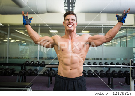Shirtless bodybuilder with arms raised in gym Shirtless bodybuilder with arms raised in gym 12179815