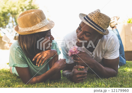 Happy couple lying in garden together Happy couple lying in garden together 12179960