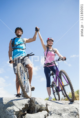 Fit cyclist couple happy to have reached the summit Fit cyclist couple happy to have reached the summit 12180001