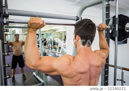 Shirtless muscular man lifting barbell in gym 12180221