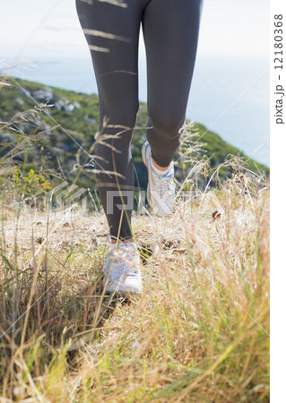 Fit woman jogging on mountain trail Fit woman jogging on mountain trail 12180368