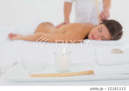 Beautiful woman receiving ear candle treatment at spa center Beautiful woman receiving ear candle treatment at spa center 12181113