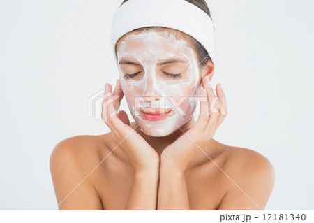 Attractive woman having white cream on her face at spa center Attractive woman having white cream on her face at spa center 12181340
