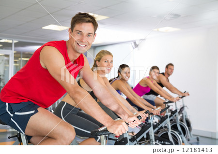 Man smiling at camera during spin class 12181413