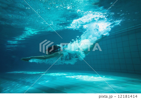 Athletic swimmer smiling at camera underwater Athletic swimmer smiling at camera underwater 12181414