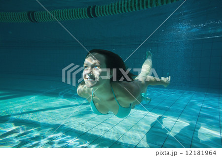 Pretty brunette smiling and swimming underwater 12181964
