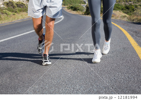 Fit couple running together up a road 12181994