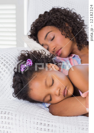 Cute daughter sleeping with mother on the sofa 12182324