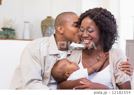 Happy parents spending time with baby on the couch Happy parents spending time with baby on the couch 12182354