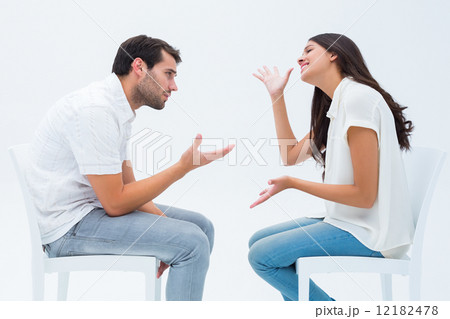 Couple sitting on chairs arguing Couple sitting on chairs arguing 12182478