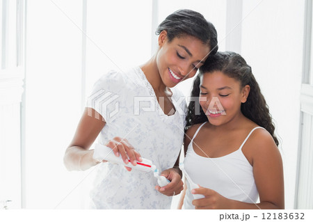Pretty mother brushing her teeth with her daughter Pretty mother brushing her teeth with her daughter 12183632
