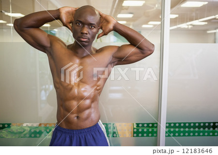Serious shirtless muscular man posing in gym Serious shirtless muscular man posing in gym 12183646