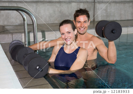 Happy couple working out with foam dumbbells 12183933