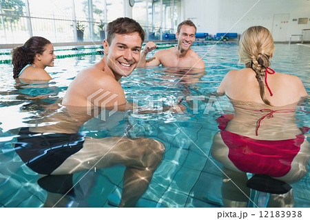 Fitness class doing aqua aerobics on exercise bikes 12183938
