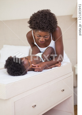 Happy mother with baby girl on changing table Happy mother with baby girl on changing table 12183941
