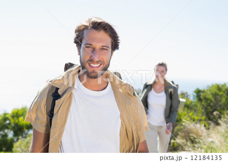 Hiking couple smiling at camera on mountain summit 12184135