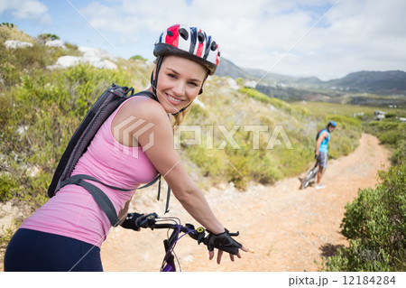 Fit couple cycling on mountain trail woman smiling at camera 12184284