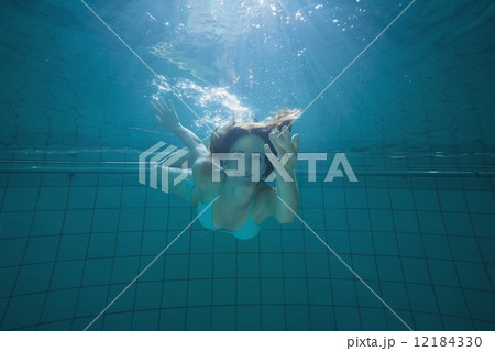 Pretty brunette smiling and offering her hand underwater 12184330