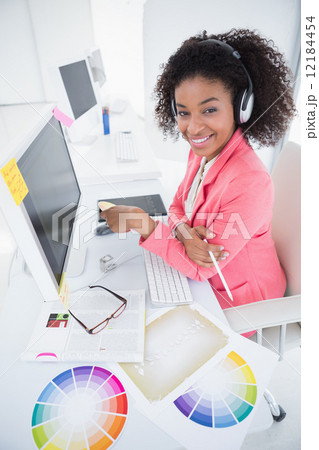 Casual graphic designer working at her desk Casual graphic designer working at her desk 12184454