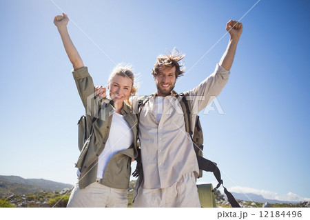 Hiking couple standing on mountain terrain smiling at camera 12184496