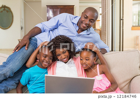 Happy family relaxing on the couch using laptop 12184746