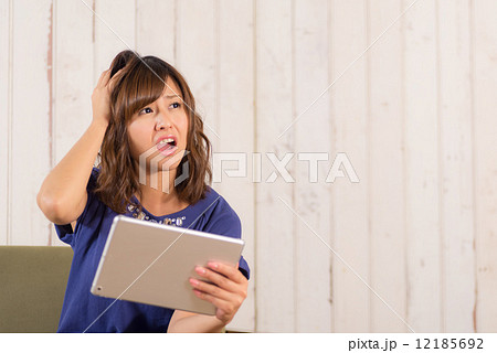 ソファに座ってタブレットPCを使う女性 ソファに座ってタブレットPCを使う女性 12185692