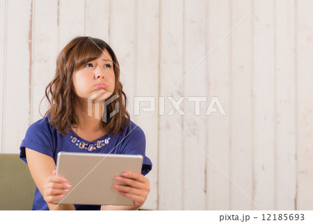 ソファに座ってタブレットPCを使う女性 ソファに座ってタブレットPCを使う女性 12185693