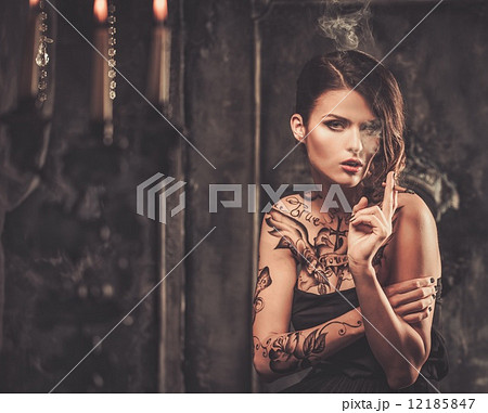 Smoking tattooed beautiful woman  in old spooky interior 12185847