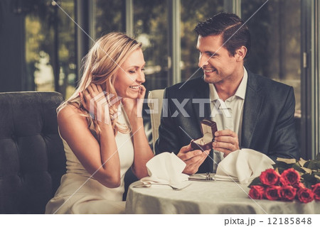 Man holding box with ring making propose to his girlfriend Man holding box with ring making propose to his girlfriend 12185848