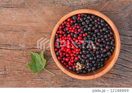 Sweet, black and red currant and green leaves in wooden bowl. Sweet, black and red currant and green leaves in wooden bowl. 12186669