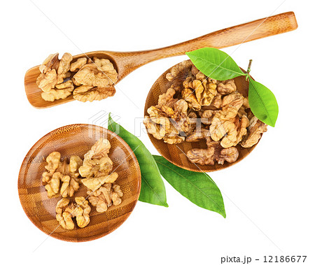 Handful of walnuts in wooden bowls, scoop and green leaves. Handful of walnuts in wooden bowls, scoop and green leaves. 12186677