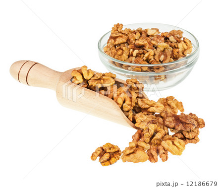 Handful of walnuts in scoop and glass bowl isolated on white. 12186679