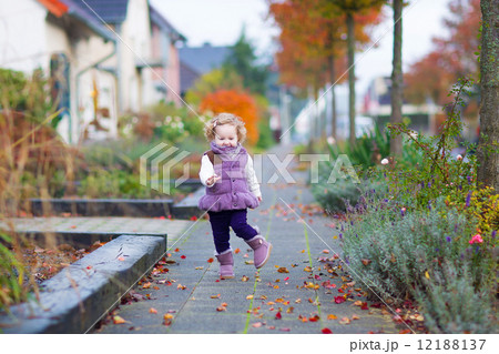 Little girl running in an autumn street 12188137