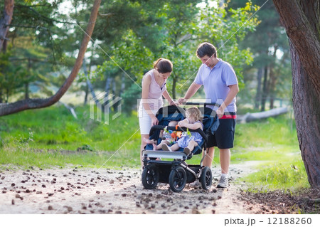 Young family hiking with two kids in a stroller 12188260