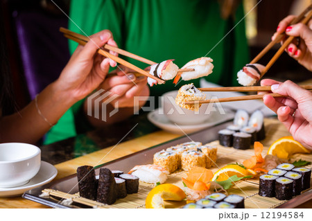 Young people eating sushi in Asian restaurant Young people eating sushi in Asian restaurant 12194584