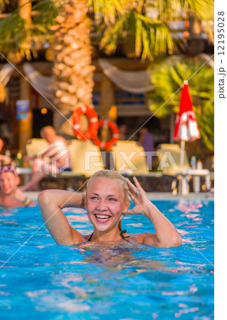 blonde woman enjoying the swimming pool at the resort blonde woman enjoying the swimming pool at the resort 12195028