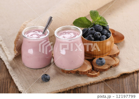yogurt with blueberries in a glass jar and blueberries in a wood 12197799