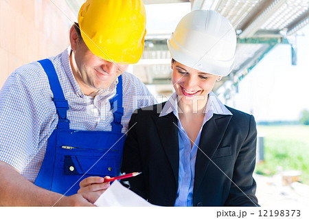 Construction Team with building plans on site 12198373