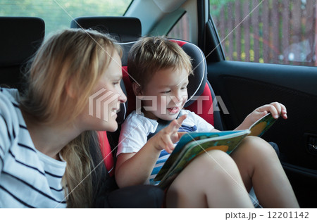 Mother and son with a book in the car Mother and son with a book in the car 12201142