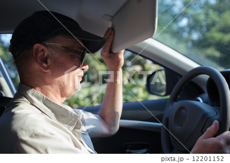 Senior driver hiding from the sun Senior driver hiding from the sun 12201152