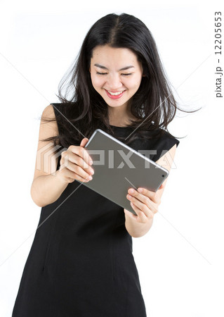 Asian lady playing a game on tablet Asian lady playing a game on tablet 12205653