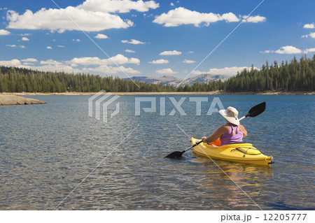 Woman Kayaking on Beautiful Mountain Lake. 12205777