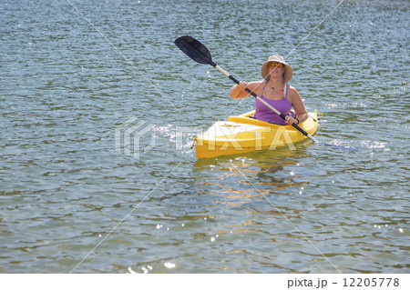 Woman Kayaking on Beautiful Mountain Lake. 12205778