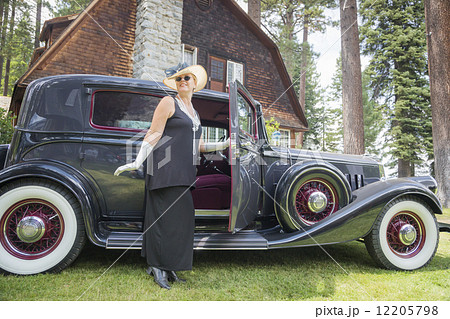 Attractive Woman in Twenties Outfit Near Antique Automobile Attractive Woman in Twenties Outfit Near Antique Automobile 12205798