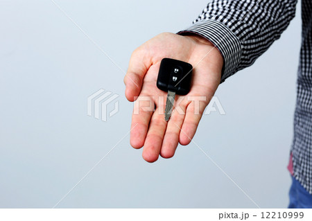 Hand holding car keys isolated on gray background 12210999