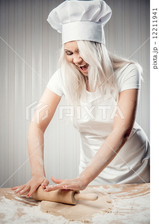 Angry and stressed out woman cook rolling dough Angry and stressed out woman cook rolling dough 12211941
