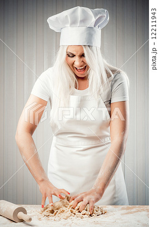 Angry and stressed out woman cook kneading dough Angry and stressed out woman cook kneading dough 12211943