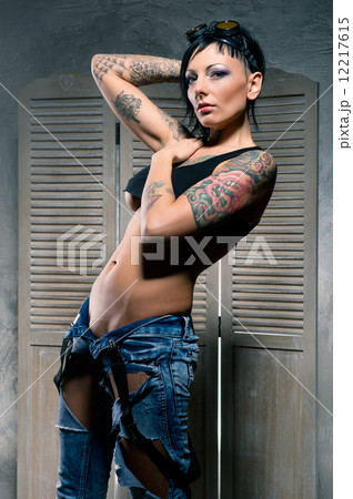 Beautiful woman with many tattoos on her body posing indoors 12217615